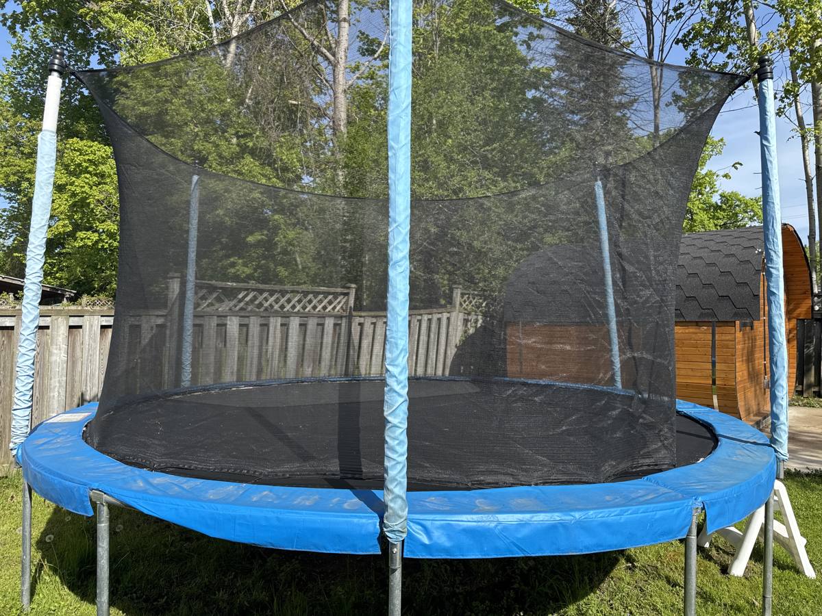 Giant trampoline with safety net on the lawn